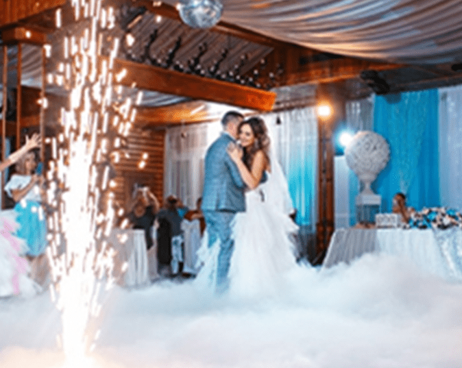 A bride and groom are dancing in the clouds.