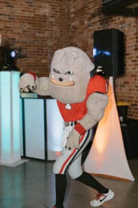 A mascot dressed in an orange and white uniform.